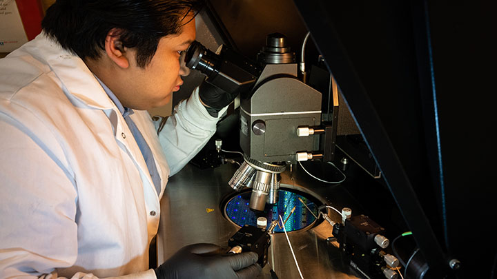 Researcher looking into microscope